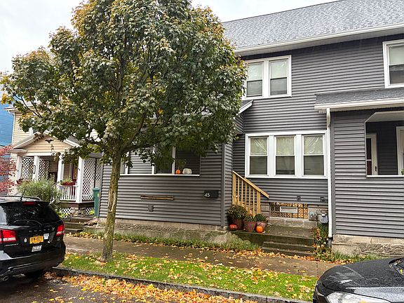 The front entrance to 45 Luzerne. A side entrance is available to the left of building. Perennial flowers installed in the strip between sidewalk and building have since bloomed. Windows (and glass block windows) shown here are for the neighboring unit.