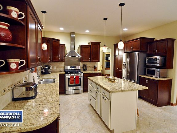 Granite tops, island, butler's station, pull-outs, pantry, tiled back-splash & pendant lighting!
