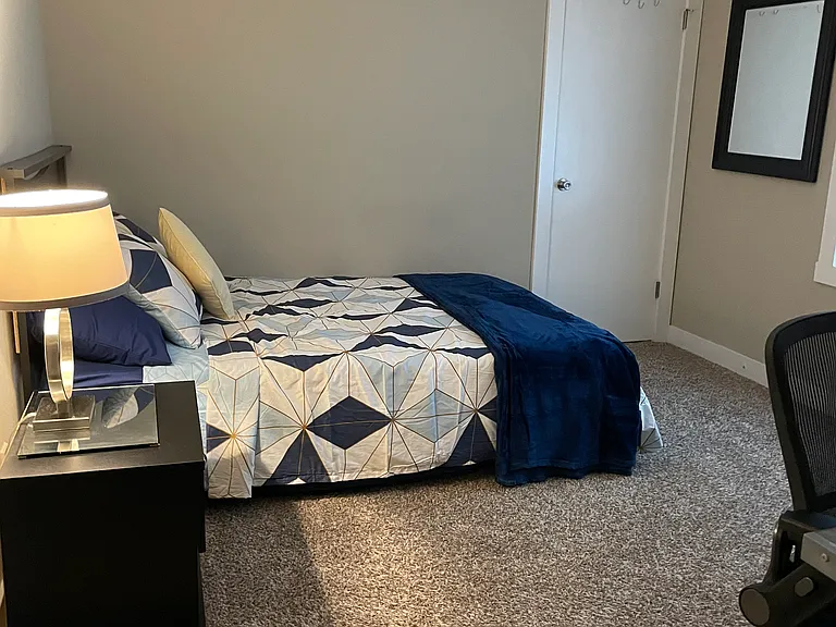 Main floor bedroom, fan, desk, queen bed, walk-in closet, dresser and under bed storage drawers