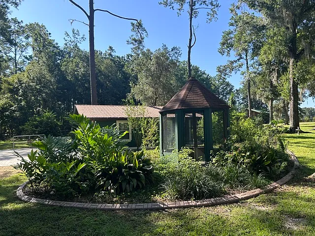 parking to the left. sliding glass door on the right of the building and an entrance door on the left leading insidec to the kitchen.