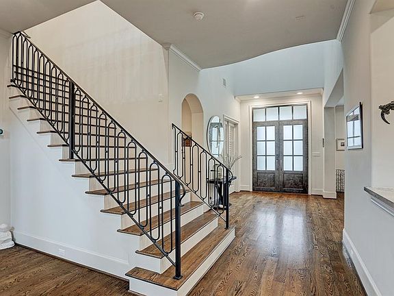 The main staircase with custom balustrades and hardwoods is centrally located.