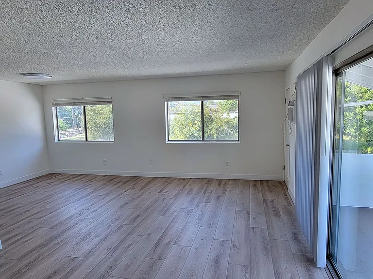 Hardison Apartments front room view of living area and balcony.