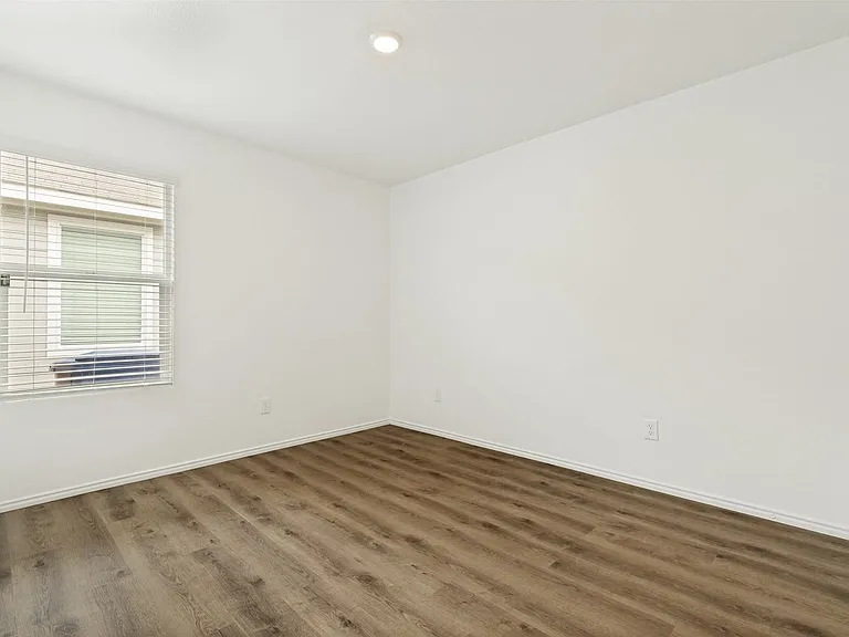 secondary bedroom with ample light and wood floor