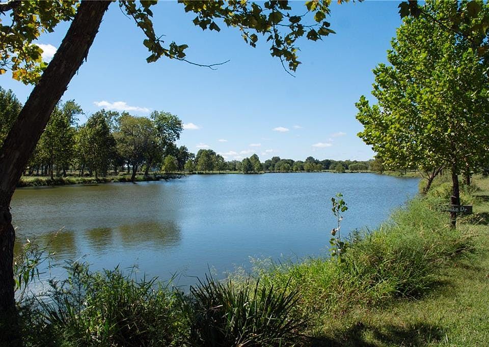 Mature trees frame the tranquil waters of a private lake on this property.