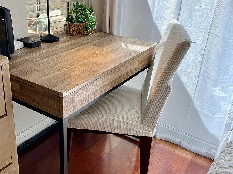 Work in comfort at the dedicated workstation, featuring a roomy desk, ample table space, desk light, convenient outlet, comfy chair, and a refreshing outdoor view.