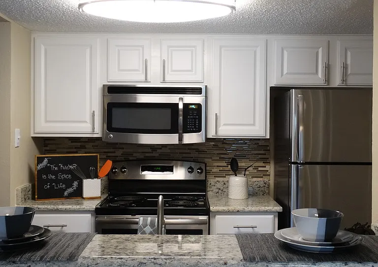 Contemporary kitchen with white cabinetry, stainless steel appliances, and ample prep space.