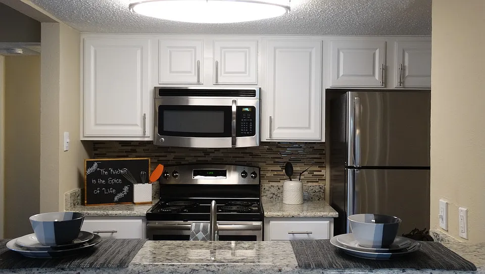 Contemporary kitchen with white cabinetry, stainless steel appliances, and ample prep space.