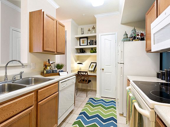Kitchen with light brown cabinets and white appliances
