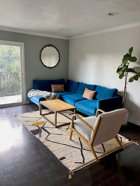 Spacious living room with espresso colored laminate flooring facing private balcony
