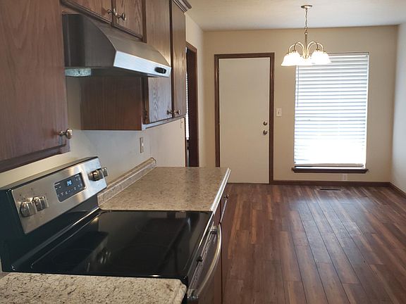 Kitchen with counters on both sides into Breakfast/dining Area to outside
