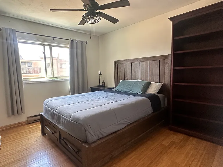 Fully furnished bedroom with window air-conditioning unit