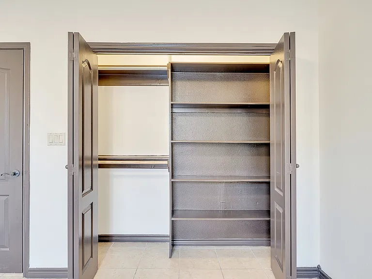 A closet with a door and shelves inside Merida Vista Apartments, showcasing the interior design in Laredo, Texas