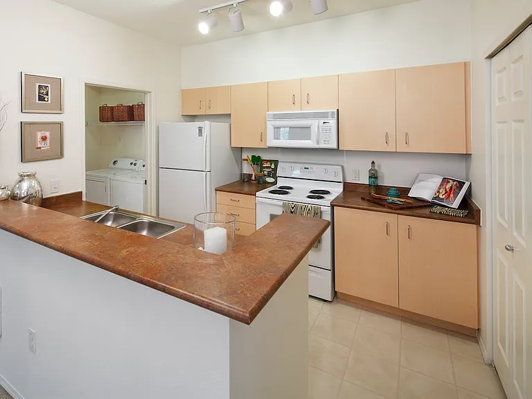 Classic Package I kitchen with oak cabinetry, laminate countertops, white appliances, and hard surface flooring