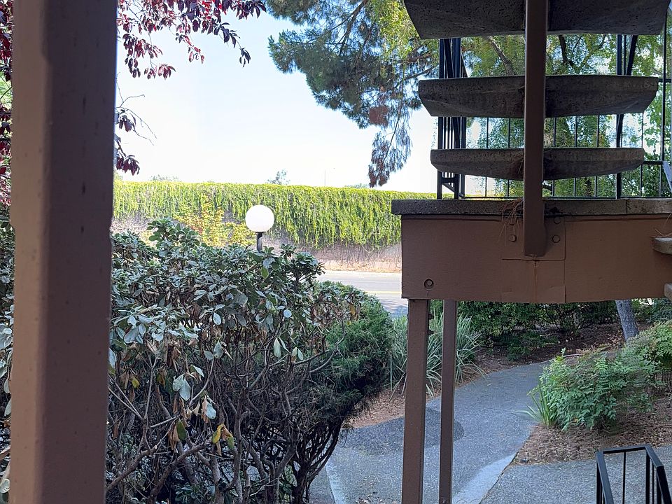 At the doorway of the unit, a lush variety of plants softens the entrance, giving the space a natural, inviting charm.