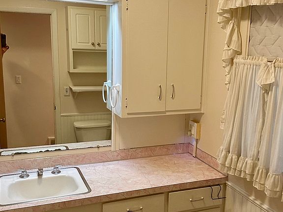 Bathroom with lots of storage cabinets, baseboard heating & cooling, tub & shower