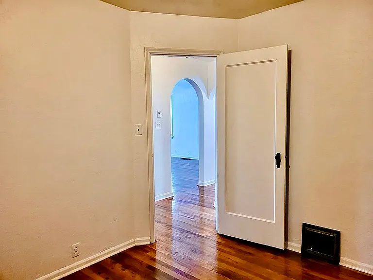 Picture taken from second bedroom. Doorway leads to hallway, bathroom immediately to the right, entrance to primary bedroom across the hall.