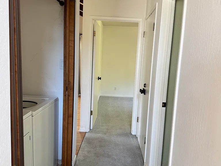 Hallway, includes washer and dryer. Two bedrooms on first floor.