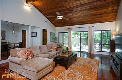 Vaulted family room with cedar ceilings and exposed beam has lots of natural light.