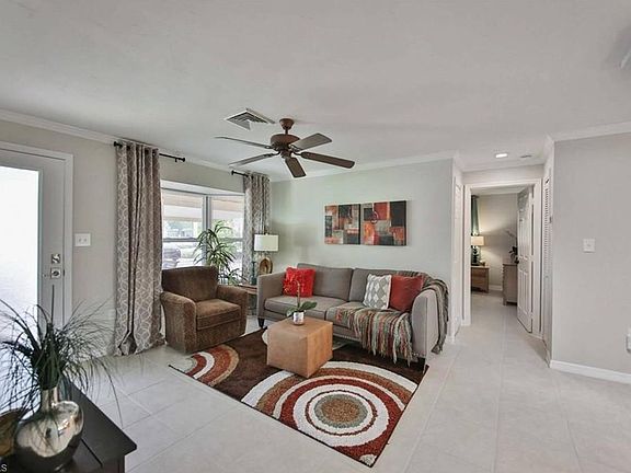 Living room features a ceiling fan, crown molding, textured walls, and new window blinds in the bay window. There is ceramic tile throughout the house.