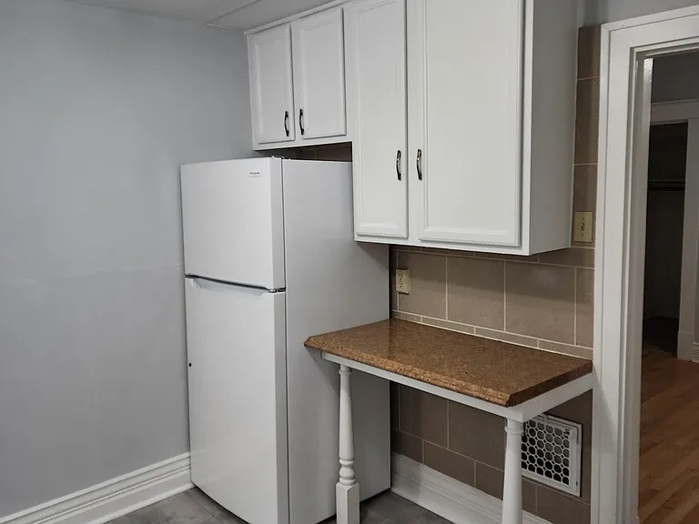 Other side of the kitchen with refrigerator and additional cabinets
