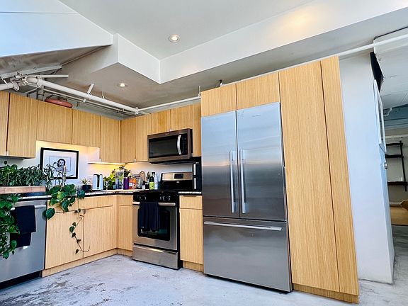 Kitchen with built-in stainless appliances: Fridge, oven/stove, dishwasher, microwave