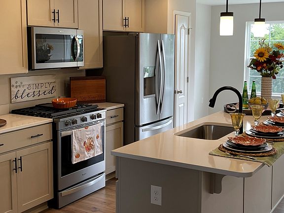 Island kitchen and adjoining morning room in a DRB Homes York II Garage model in the Homestead Acres