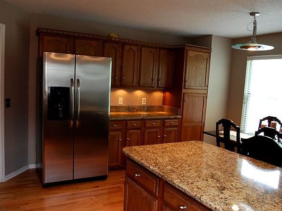 kitchen with granite counters, bar, and stainless appliances