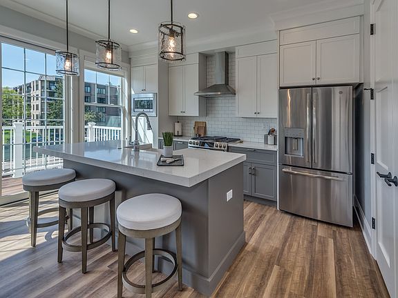 Kitchens feature stone countertops and stainless steel appliances.