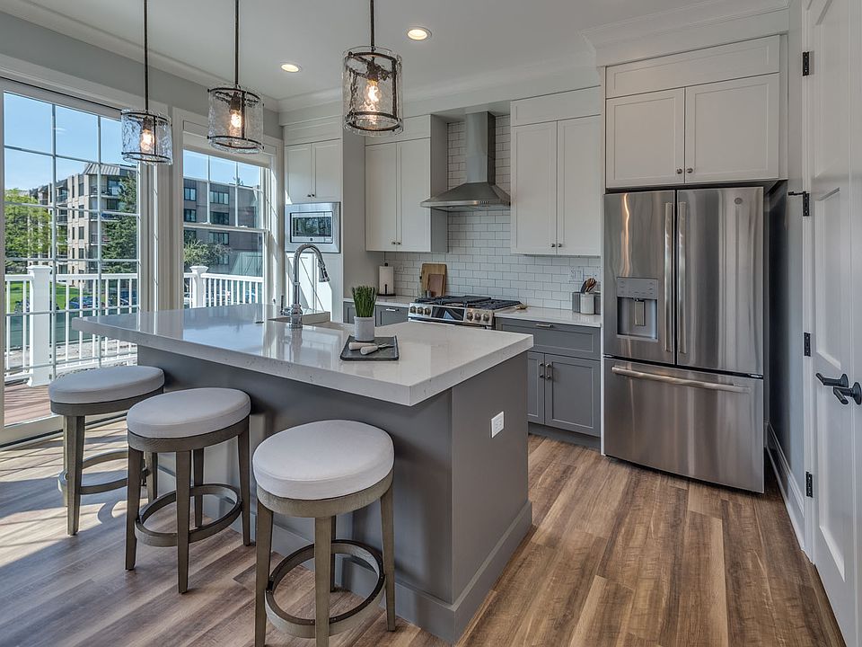 Kitchens feature stone countertops and stainless steel appliances.