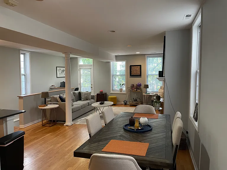 Open dining area next to the kitchen with hardwood floors, space for a full-size dining table, and an easy flow into the main living area.