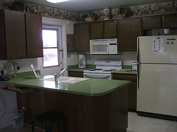 Spacious kitchen with refrigerator and breakfast bar.