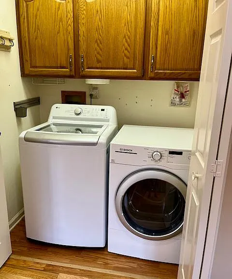Large capacity Washer & Dryer with cabinet storage located in Kitchen area.
