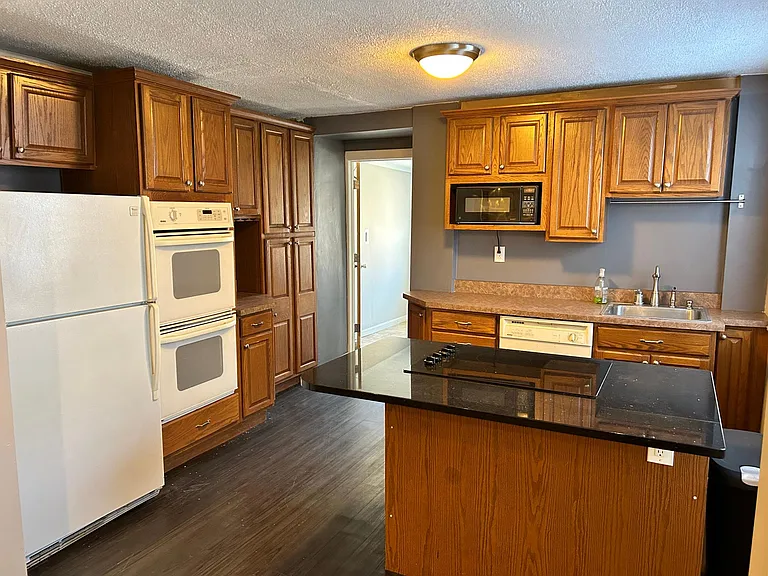 Kitchen has double oven, dishwasher, refrigerator cooktop and microwave. It is to the right as you enter.