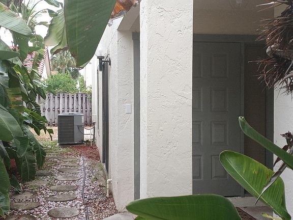 Front entrance, when you open up the gate to the left of the house. This is the view of side of house straight through to the backyard. Newer AC unit on side.