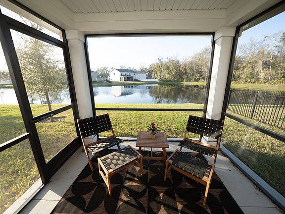 Screened in back patio with view of pond and preserve.