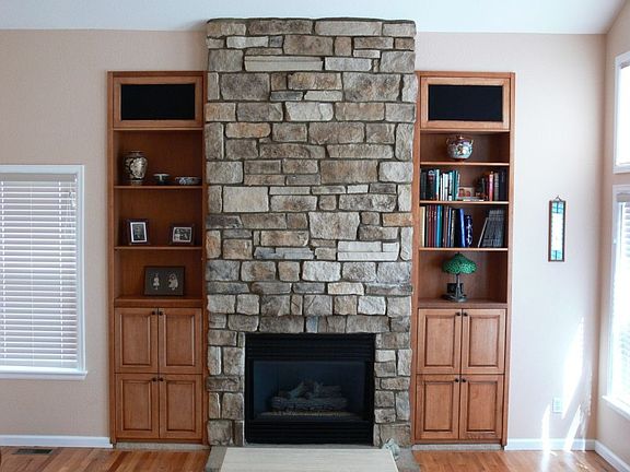Stone fireplace in familyroom flanked by custom built-in book cases