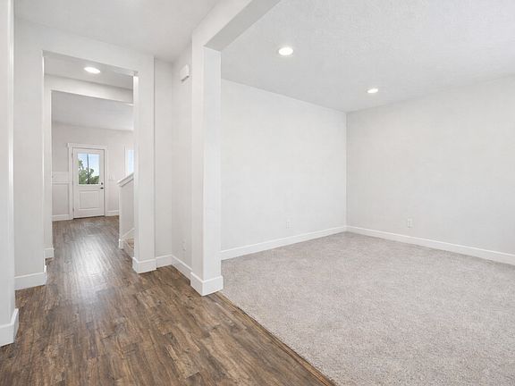 Entrance to the home with the living room on the right and formal dining/den on the left. No Furniture.
