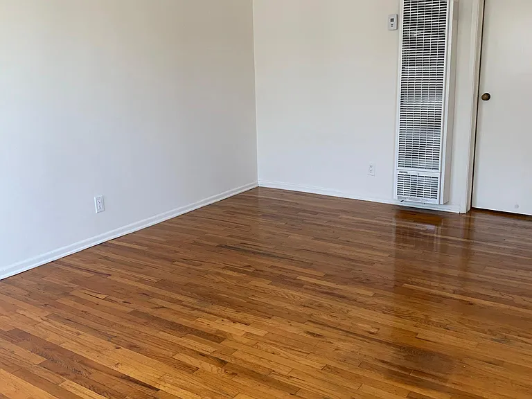Living room. hardwood floors throughout . Wall heater.