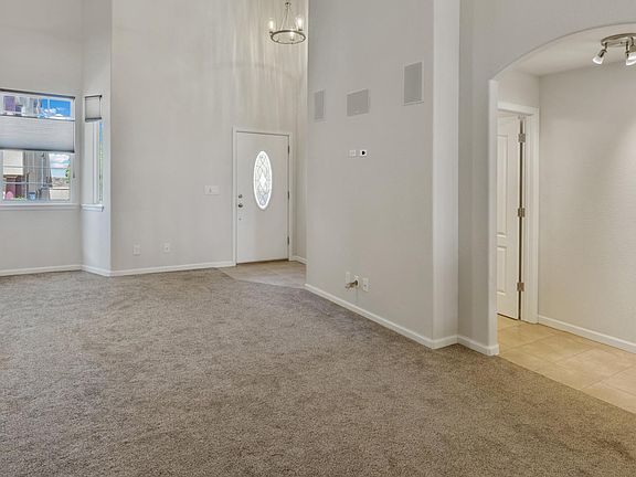 POV 1 - Our Casa Bonita's spacious living room has vaulted ceilings, in-wall speakers, bay windows, a large ceiling fan with clear blades, high pile plush carpet, and a gas heater. Hunter Douglas honeycomb window treatments throughout home.