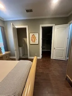 Master bedroom. Door on the right is the walk-in closet; door to the left houses washer/dryer with shelving and cabinetry for storage.