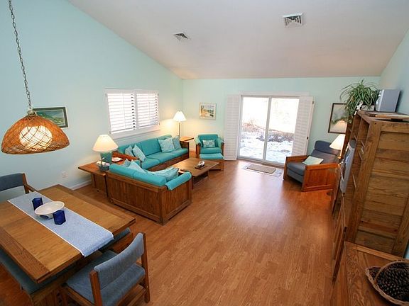 Open living/dining room with slider to patio over looking golf course.