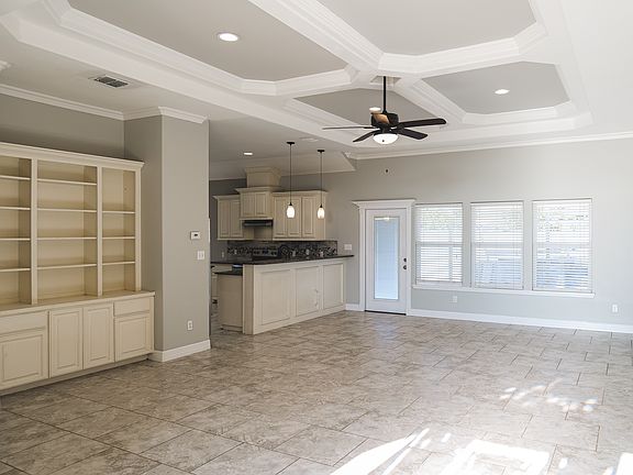 living room with built-in cabinets that's open to kitchen