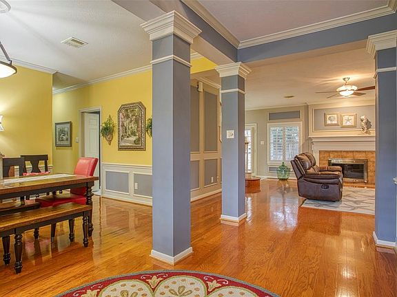 Entryway with Hardwood Flooring through Formal Dining, Den and Primary.