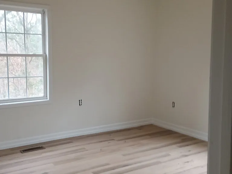 Additional bedroom with new flooring and paint.