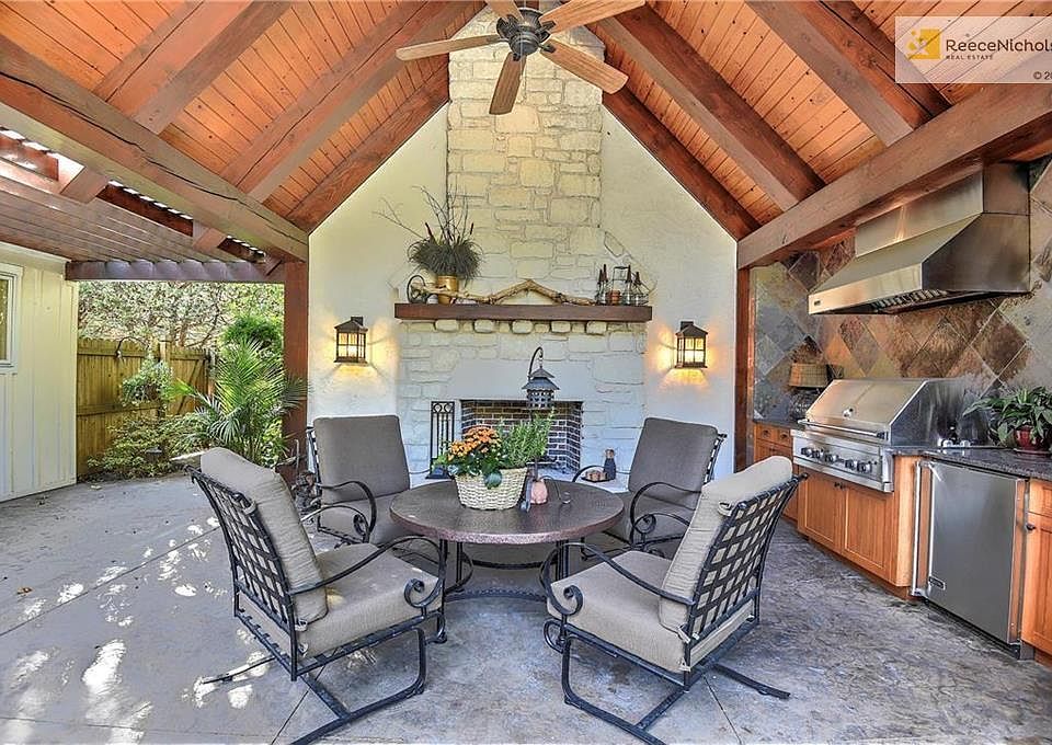 This covered patio boasts a cozy fireplace and a built-in Viking grill/fridge.