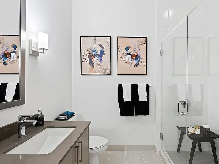 Primary bath with grey quartz countertops and hard-surface vinyl plank flooring
