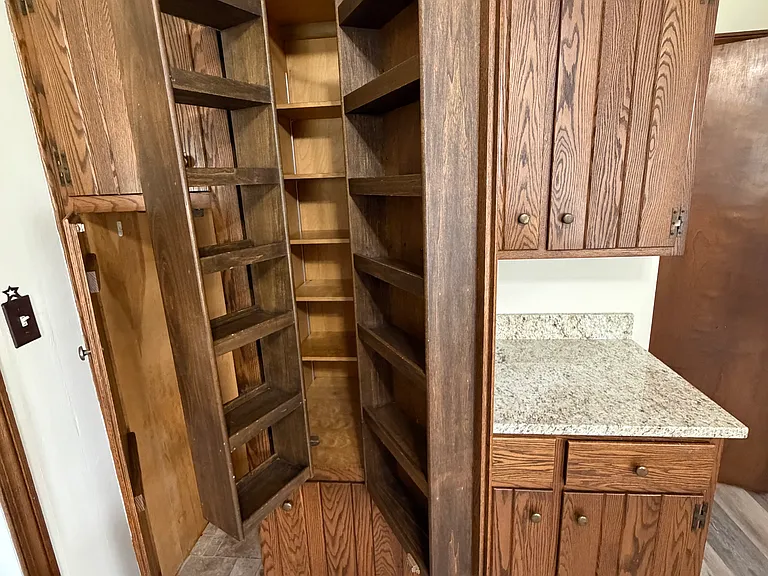 Custom red oak solid wood cabinets feature this fold-out spice or canned goods storage rack.
