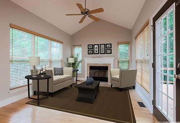 Virtually Staged Photo.  Vaulted Hearth Room, Door to Deck, Breakfast room and Fireplace.  Loads of natural light and wood floors.