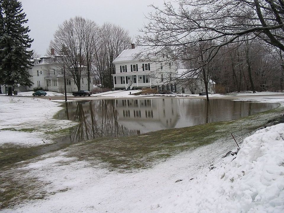 Home reflected in puddle of snowmelt -- Winter 2005