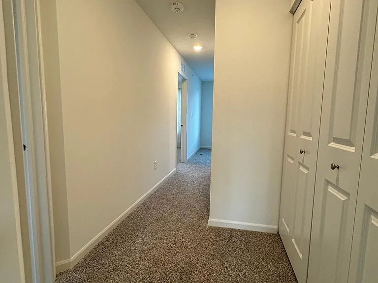 Upstairs hallway leading to primary bedroom, second bedroom, loft, second bathroom, and washer/ dryer room.